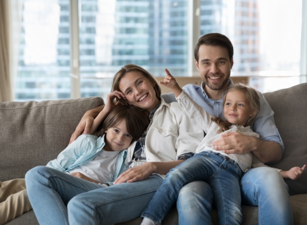 a mother and father relax on their couch with their two daughters in DeWitt, Iowa