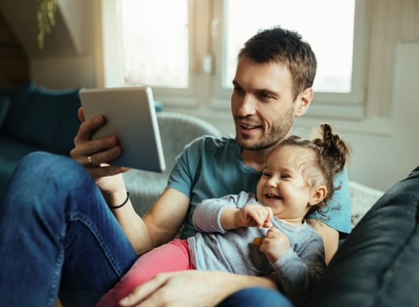 A father reads to his daughter on their couch in DeWitt, IA