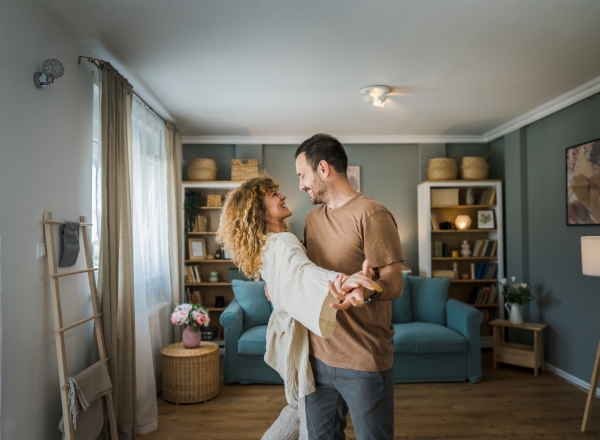 A happy couple is dancing while waiting for Heat Pump Replacement in DeWitt, IA